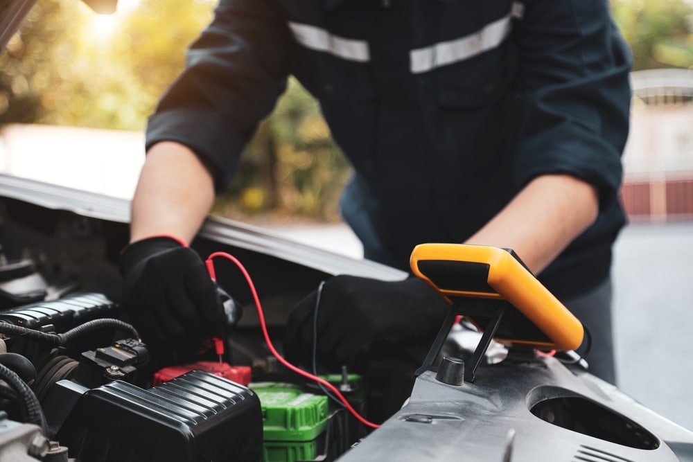 Car mechanic use voltmeter to check voltage battery low energy problem for car care service maintenance and re charger or jump start or change battery