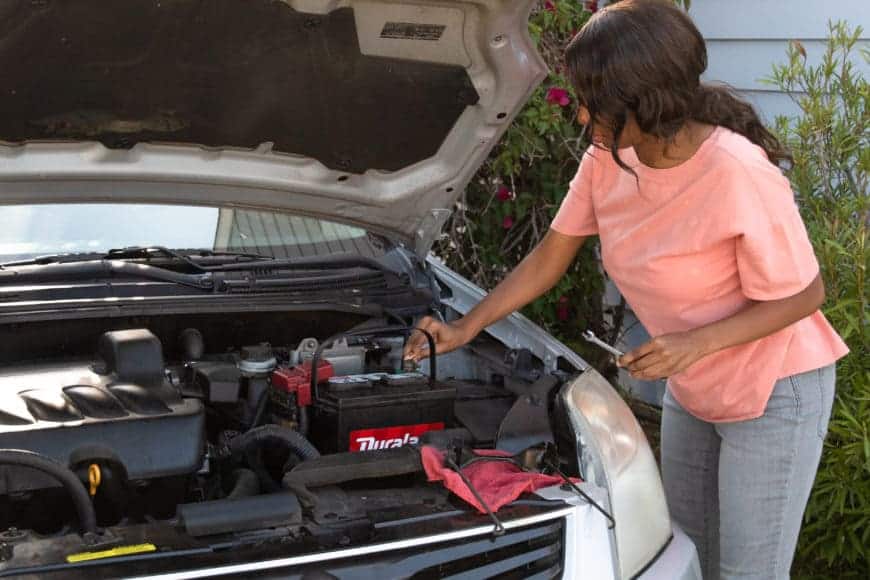 female working with a car battery