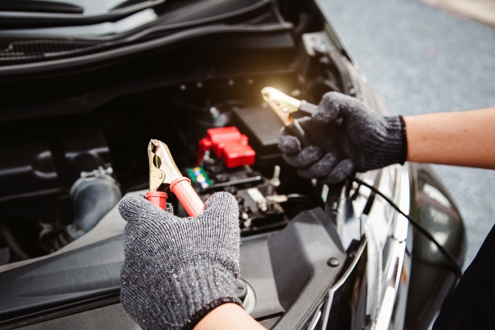 Close up Hand Auto Mechanic Using Connect Jumper Cables On Terminal