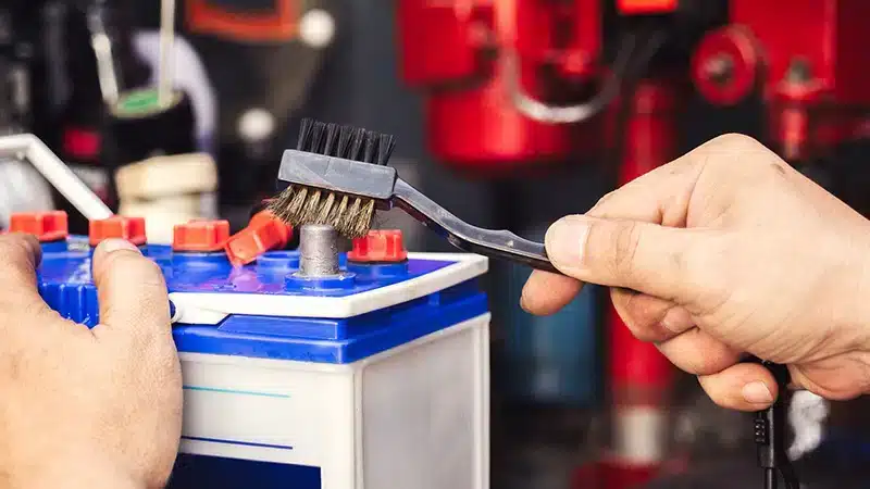 close up of male hands cleaning car battery