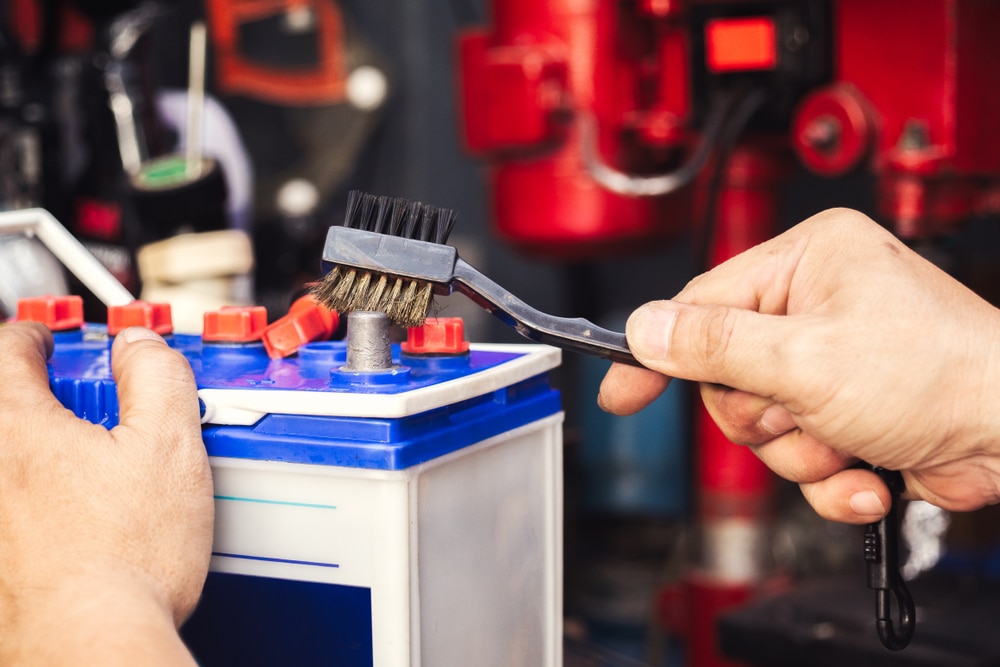 mechanic cleaning a battery connections