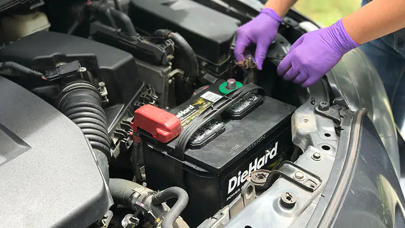 view of male hands changing the car battery