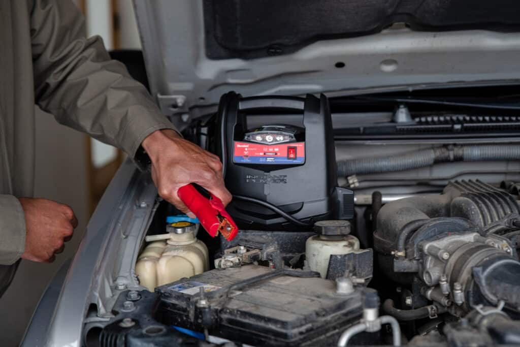 zoomed view of someone jump starting the battery