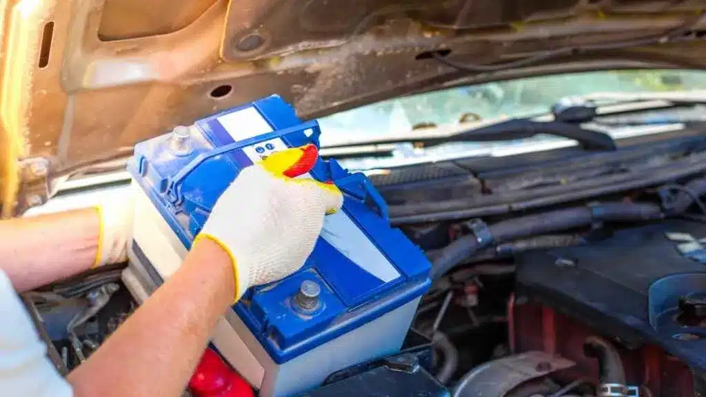 zoomed view of two hands working with car battery