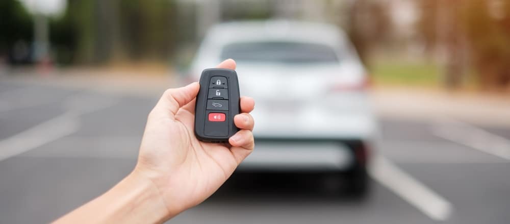 Hand Holding Car Remote Control Smart Key To Lock 