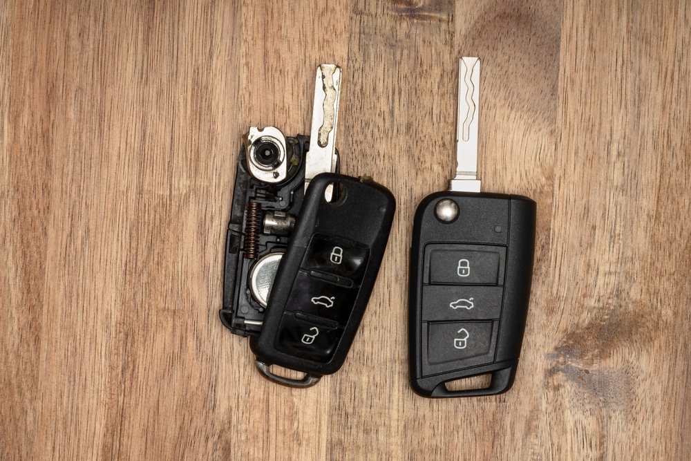 2 key fob batteries placed on a wooden surface