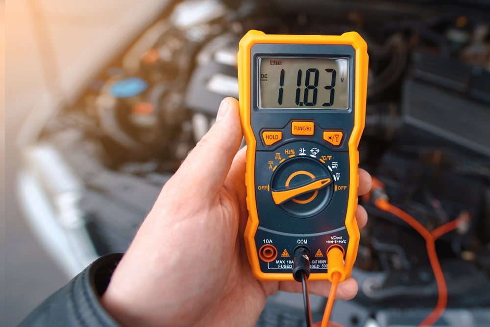 Man Testing Car Electrical System Including Battery Alternator For Winter